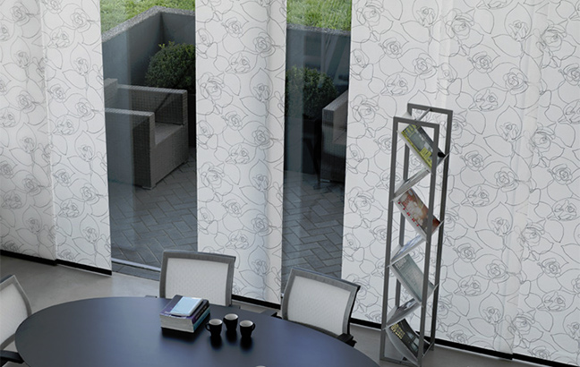 Elegantna panelna zavesa z vzorci razbije monotonost v moderni pisarni.
